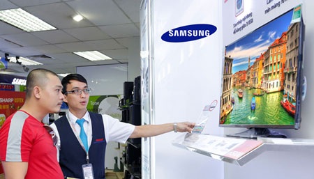 Chọn TV hỗ trợ DVB-T2 để đón đầu lộ trình số hóa - 1 Người tiêu dùng đang tham khảo các mẫu TV mới tại một cửa hàng điện máy
