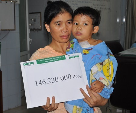 Mẹ con bé Thùy Dương nhận quà bạn đọc Dân trí.
