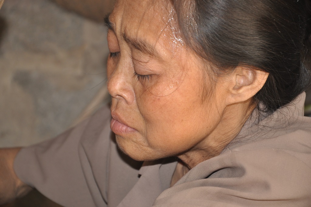 Mệt lả nhưng chị vẫn gắng gượng ngồi dậy để sắc chén thuốc.