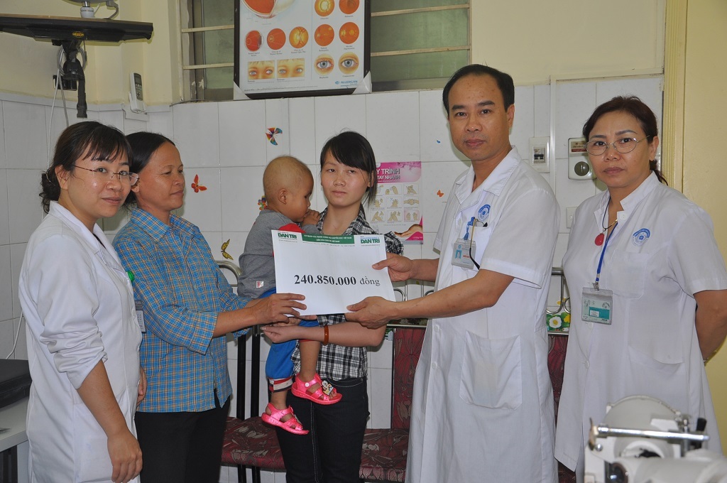 Bác sĩ Nguyễn Xuân Tịnh- Phó khoa Nhi BV Mắt TW thay mặt trao quà cho gia đình bé Phong.