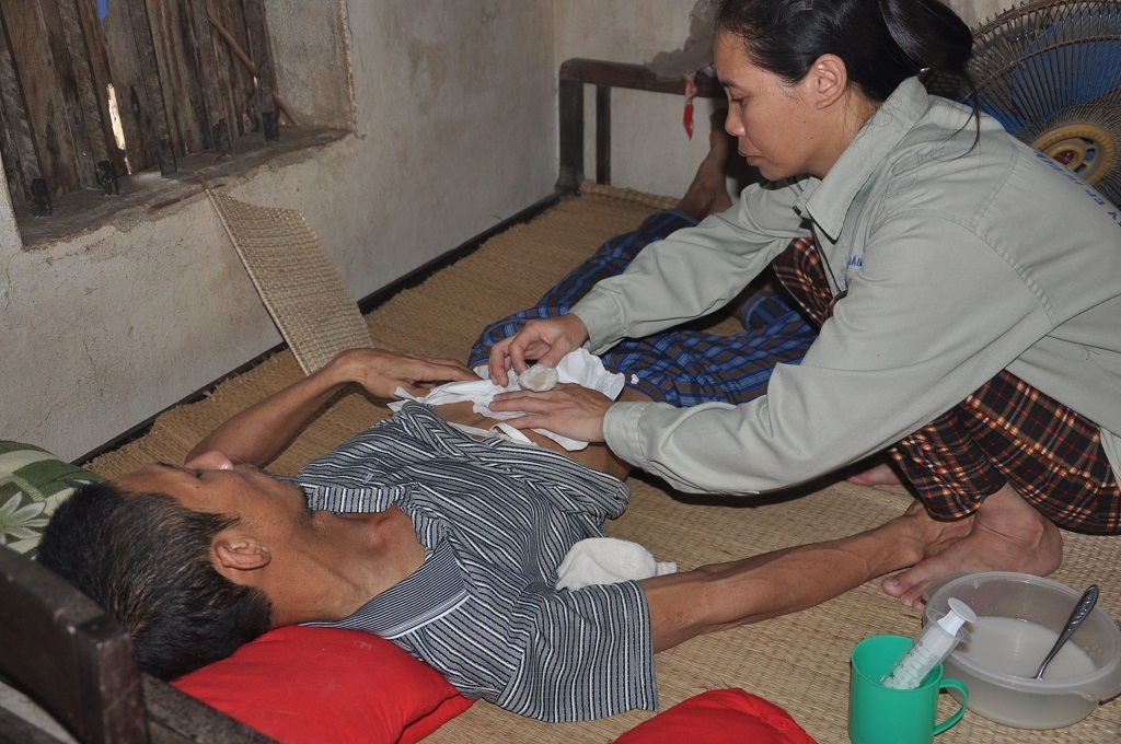 Hàng ngày chị Huệ phải bơm cháo loãng qua ống xông để chồng cầm cự.