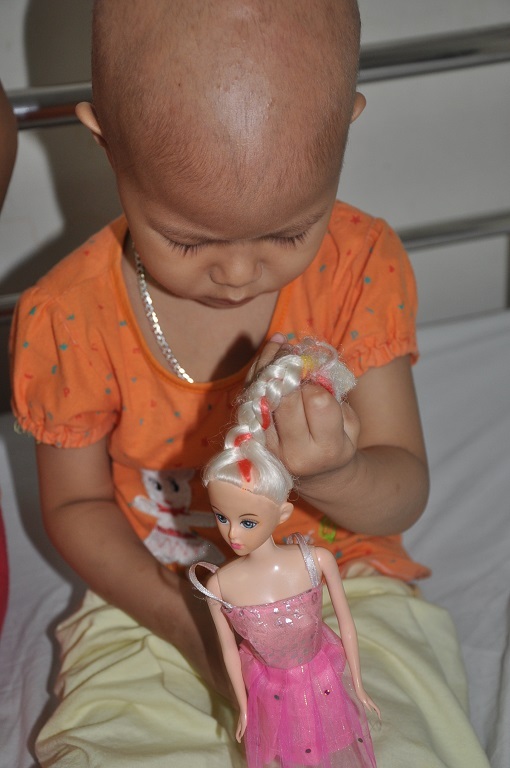 Ở viện bé Linh có con búp bê làm bạn để vỗ về, ôm ấp.