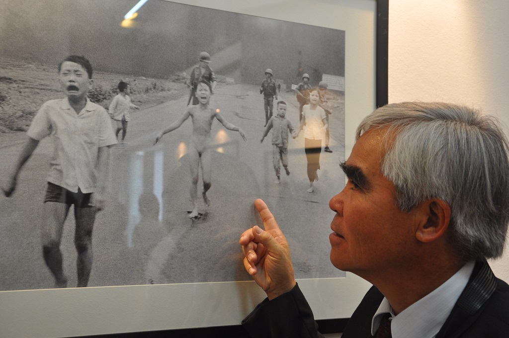 Nick Út bên bức ảnh em bé Napal nổi tiếng ông chụp tháng 8/1972.