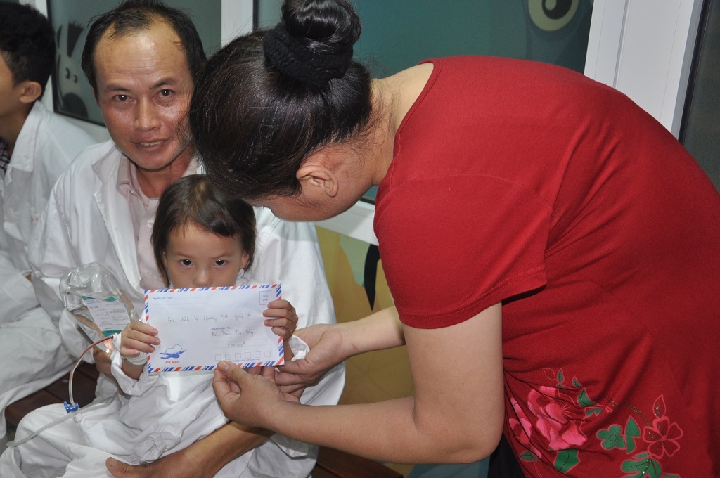 Em bé dễ thương vui mừng nhận được quà của bác Huyền cho.