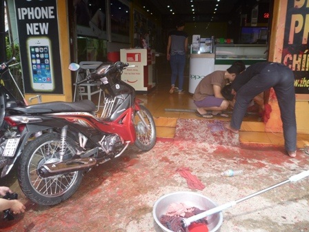 Nhân viên đang dọn dẹp cửa hàng dính đầy nước sơn cộng với phân bò