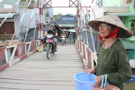 Hàng ngày bà Chiếu lên giữa cầu xin tiền những người đi chợ về nuôi cháu học hành