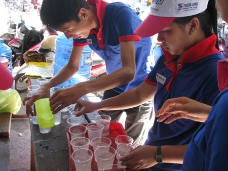 Các sinh viên tình nguyện chuẩn bị những ly nước chanh đá mát rượi.
