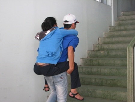 Kim Vân được các bạn sinh viên tình nguyện cõng đi về mỗi buổi thi. (Ảnh: Khánh Hồng)