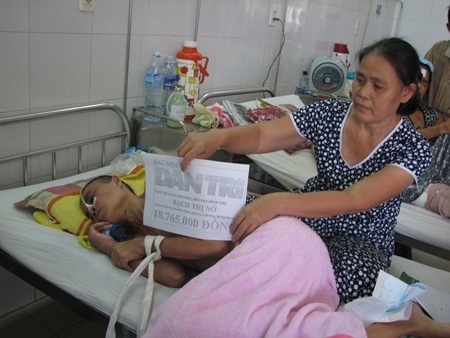 Chị Bạch Thị Ý thay mặt gia đình nhận số tiền bạn đọc Dân trí ủng hộ chị Nở 