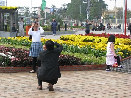 Cô bé được ba chụp hình cho tại đường hoa Bạch Đằng