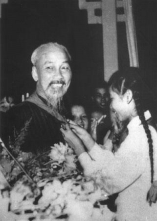 Phương Thảo với đôi bím tóc dài đang cười tươi quàng khăn cho Bác Hồ (Ảnh tư liệu)