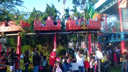 Khu vui chơi đông nghịt người chiều mùng 2 Tết - 4 Phía trên các bạn đang được đi tàu lửa, phía dưới nhiều bạn nhỏ đang sốt ruột đợi đến lượt mình