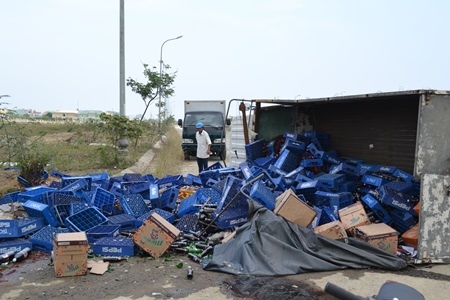 Chiếc xe tải bị lật nhào, nhiều thùng nước ngọt đổ tràn ra đường