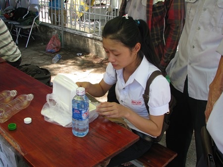 Một thí sinh nhận cơm và ăn ngay tại chỗ. (Ảnh: Khánh Hồng)