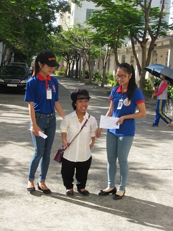 Uyên được hai sinh viên tình nguyện dẫn đến phòng thi làm thủ tục.