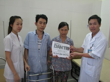Bác sĩ Huỳnh Tấn Tuệ trao tiền của bạn đọc ủng hộ cho hai mẹ con em Phan Văn Nghĩa