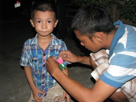 Các em nhỏ cũng được bố mẹ đưa đến chùa để gắn hoa hồng cài áo