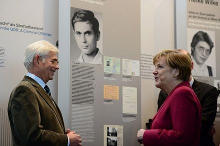 Bà Merkel trò truyện với một quan chức tại triển lãm.