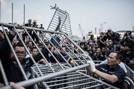 Các nhân viên an ninh tháo dỡ rào chắn trong vòng vây của rất đông nhà báo.