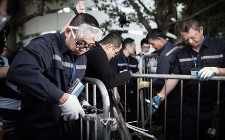 Một nhân viên an ninh cắt dây buộc trên các hàng rào chắn.