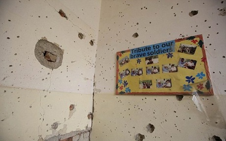 Tờ tranh treo ảnh của các học sinh vẫn còn nguyên trên bức tường chằng chịt những vết đạn.