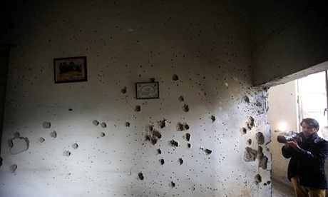 Tờ tranh treo ảnh của các học sinh vẫn còn nguyên trên bức tường chằng chịt những vết đạn.