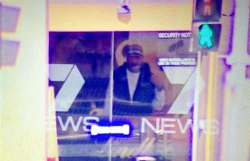 Một tay súng bị ghi hình qua cửa sổ quán cà phê.