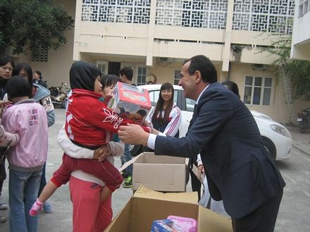 Các cán bộ Đại sứ quán trao quà tận tay cho các em nhỏ.