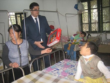 Các cán bộ Đại sứ quán trao quà tận tay cho các em nhỏ.