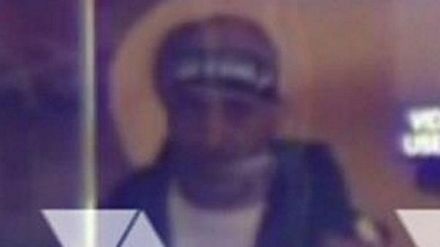 Nghi phạm được ghi hình qua cửa sổ của quán cà phê.