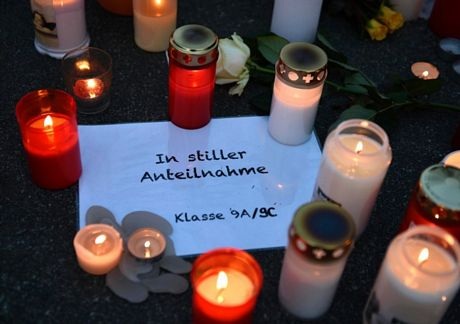 Những cây nến được thắp lên bên thông điệp tưởng nhớ các học sinh xấu số.