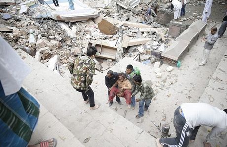 Một phụ nữ bị thương được khiêng ra từ đống đổ nát.