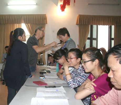 Thầy Paul lắng nghe và uốn nắn phát âm cho một nữ học viên trung niên.