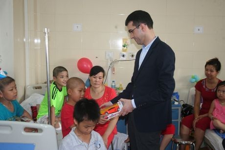 Một cán bộ Đại sứ quán Azerbaijan trực tiếp phát từng phần quà cho các bệnh nhi.