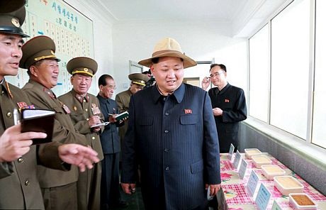 Ông Kim phanh áo ngoài, để lộ bụng khá lớn, trong chuyến thăm nông trại.