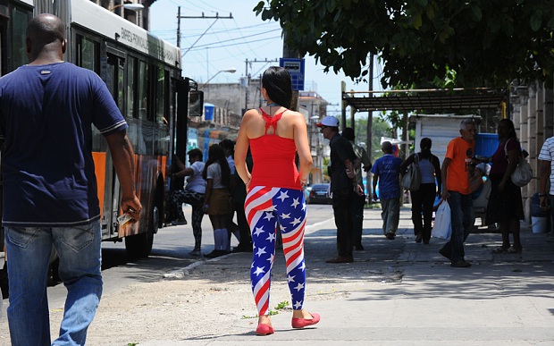 Hôm nay, Cuba sẽ mở lại đại sứ quán tại Mỹ sau 54 năm - 3 Một phụ nữ mặc trang phục tái hiện quốc kỳ Mỹ trên đường phố Havana (Ảnh: AFP)