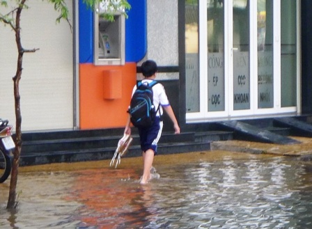 Nhiều em học sinh phải cởi giày, xắn quần vượt lũ đến trường