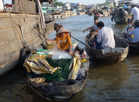 “Má hồng” nhọc nhằn mưu sinh ở chợ nổi Cái Răng - 5 Một du khách thưởng thức tô bún riêu nóng hổi ngay trên sông