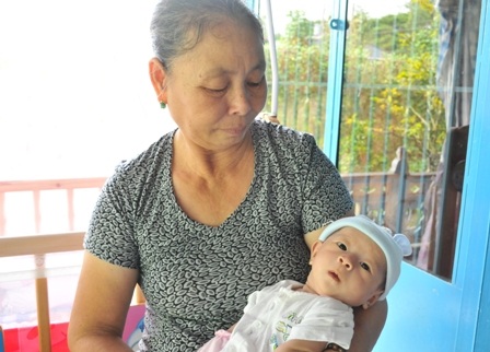Gia đình mừng đầy tháng cho cháu bé bị văng khỏi bụng mẹ - 6 Sáng nay bé Huy được bà ngoại bế đi tiêm vắc xin