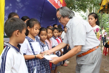 Nhà báo Phan Huy - Trưởng VPĐD báo Dân trí Khu vực ĐBSCL cùng trao học bổng cho các em học sinh