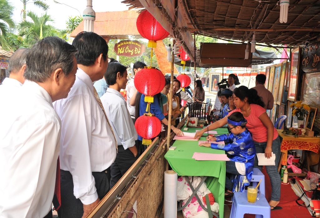 Rất đông khách tham quan đến xem ông đồ nhí viết thư pháp