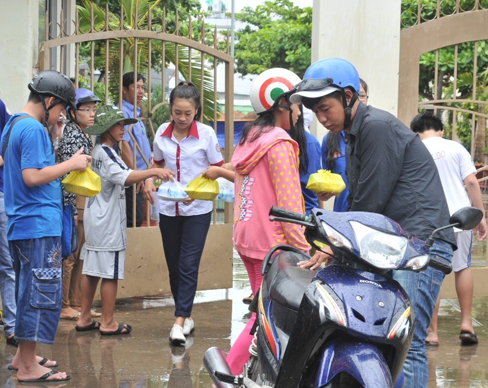 “Chiến sĩ nhí” phát cơm, nước uống cho các anh chị thí sinh - 6 Dù trời mưa các chiến sĩ lớn, chiến sĩ nhỏ cùng tham gia phát cơm cho các thí sinh và phụ huynh.