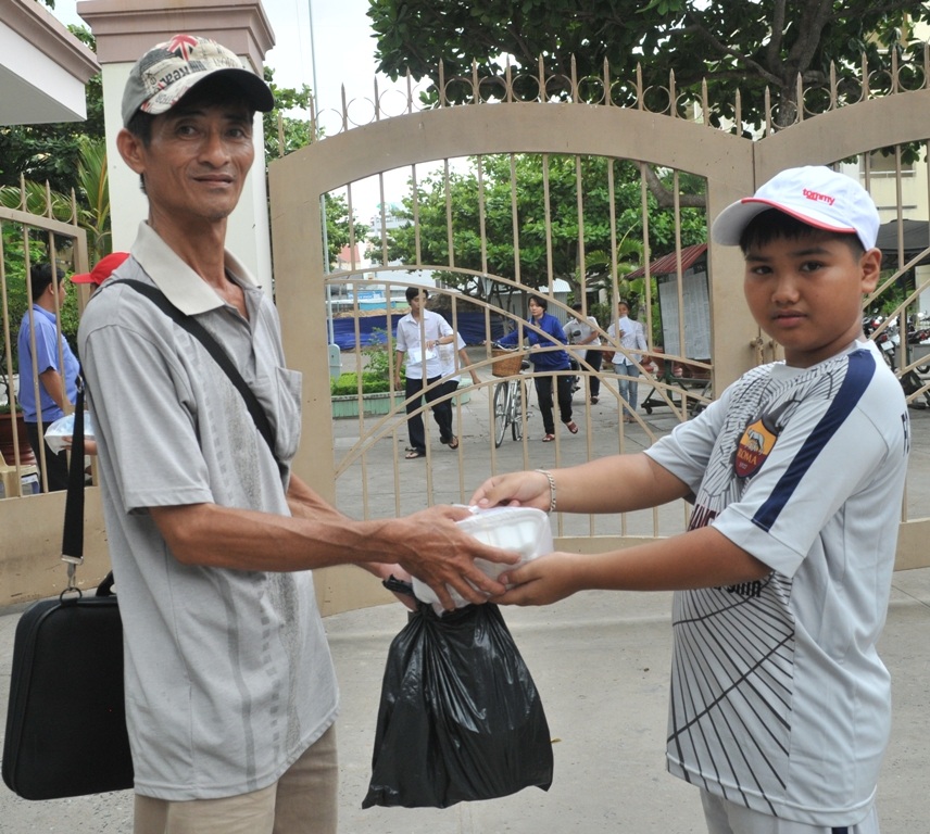 “Chiến sĩ nhí” phát cơm, nước uống cho các anh chị thí sinh - 3 Chiến sĩ nhí Hoàng nam trao cơm cho một phụ huynh