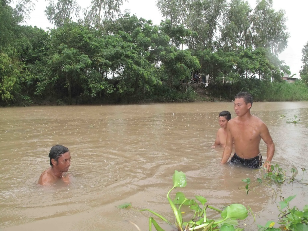 Chồng đập phá mộ vợ, vứt hài cốt xuống sông - 2 Người thân bà T. lặn tìm hài cốt của bà nhưng chưa thấy.