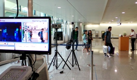 Hành khách đi qua máy đo thân nhiệt từ xa