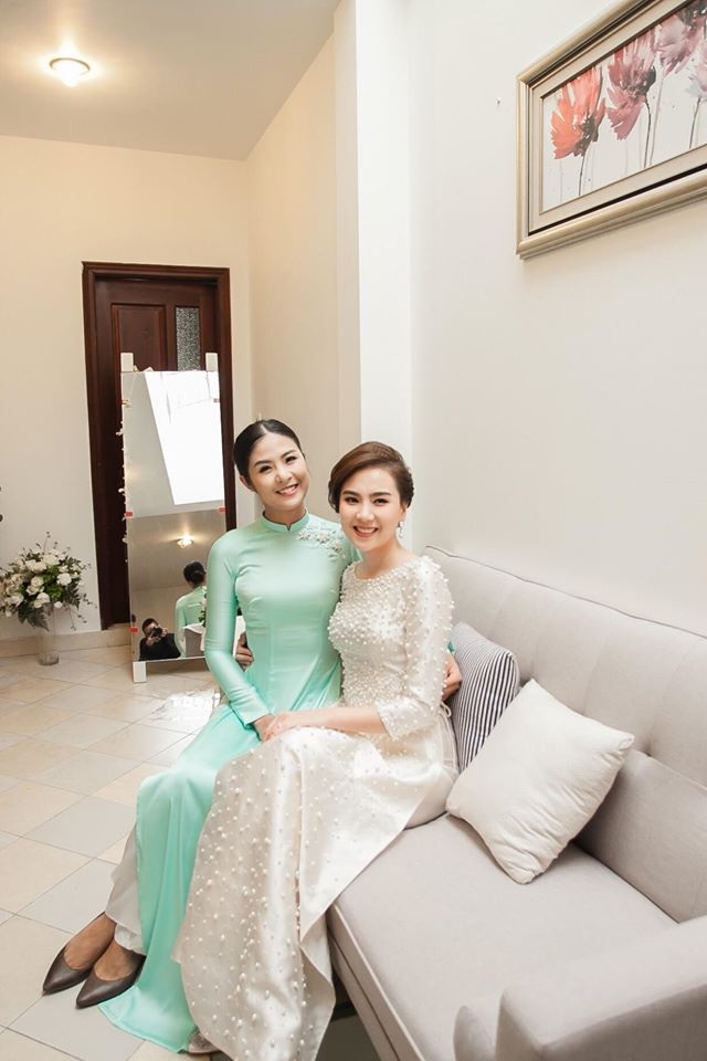 “Cô gái thời tiết” Mai Ngọc hôn chồng đắm đuối trong lễ ăn hỏi - 18 Sau khi xong các thủ tục theo truyền thống, biên tập viên 9X thay một bộ áo dài khác chuẩn bị cho lễ đón dâu. Cô chọn bộ áo dài màu trắng kem được điểm xuyết bằng hàng 2.000 viên ngọc trai đủ kích thước. Thiết kế cổ thuyền và đường chiết eo lấy cảm hứng từ những bộ áo dài của bà Trần Lệ Xuân, vợ cố vấn Ngô Đình Nhu, biểu tượng của thời trang Việt Nam thập niên 50-60 của thế kỷ trước.