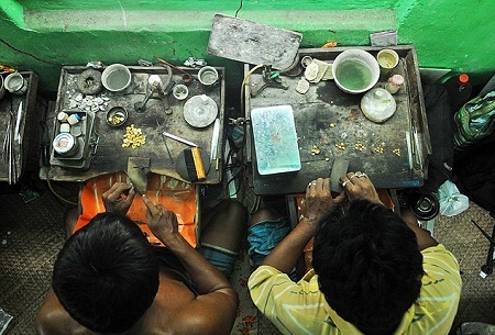 Một
người thợ kim hoàn đang chế tác một đôi vòng bằng vàng tại một cửa hiệu ở thành
phố Kolkata.