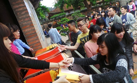 Xếp hàng mua giấy, nhận
số thứ tự để chuẩn bị bước sang khu vực các ông đồ viết chữ.