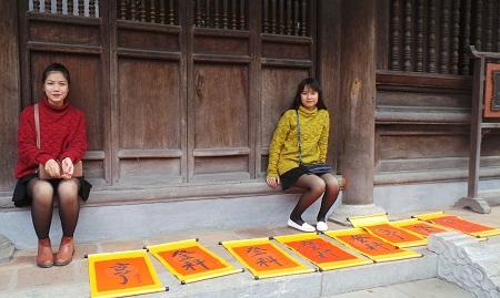 Hai cô gái được các bạn
“giao nhiệm vụ” ngồi trông các bức thư pháp, chờ mực khô.