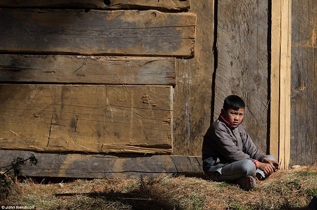Hình ảnh “đất nước hạnh phúc nhất thế giới” - 9 Một
cậu bé người Bhutan ngồi một mình trước cửa nhà.